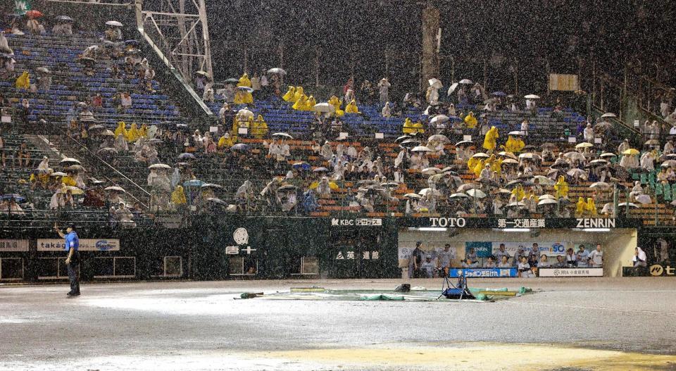 　降雨コールドゲームを告げる審判（左端）。後方はロッテベンチ