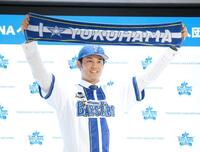 　入団会見でマフラータオルを掲げる藤浪（撮影・金田祐二）