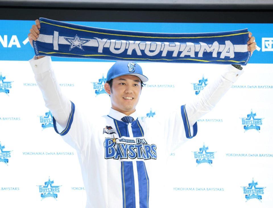 　入団会見でマフラータオルを掲げる藤浪（撮影・金田祐二）