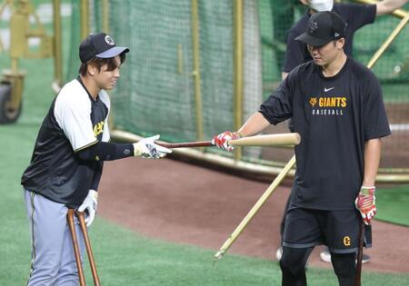 　坂本（右）にバットを手渡す梅野（撮影・西岡正）