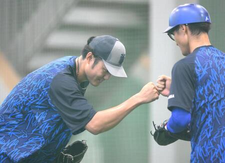 　ブルペンでの投球練習を終えてタッチを交わす藤浪（左）＝撮影・堀内翔