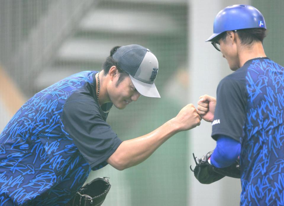 　ブルペンでの投球練習を終えてタッチを交わす藤浪（左）＝撮影・堀内翔