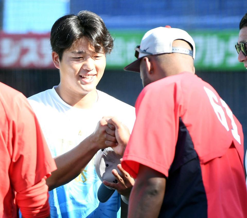 　昨夜の死球を謝罪する中村優（左）とグータッチするファビアン（撮影・佐藤厚）