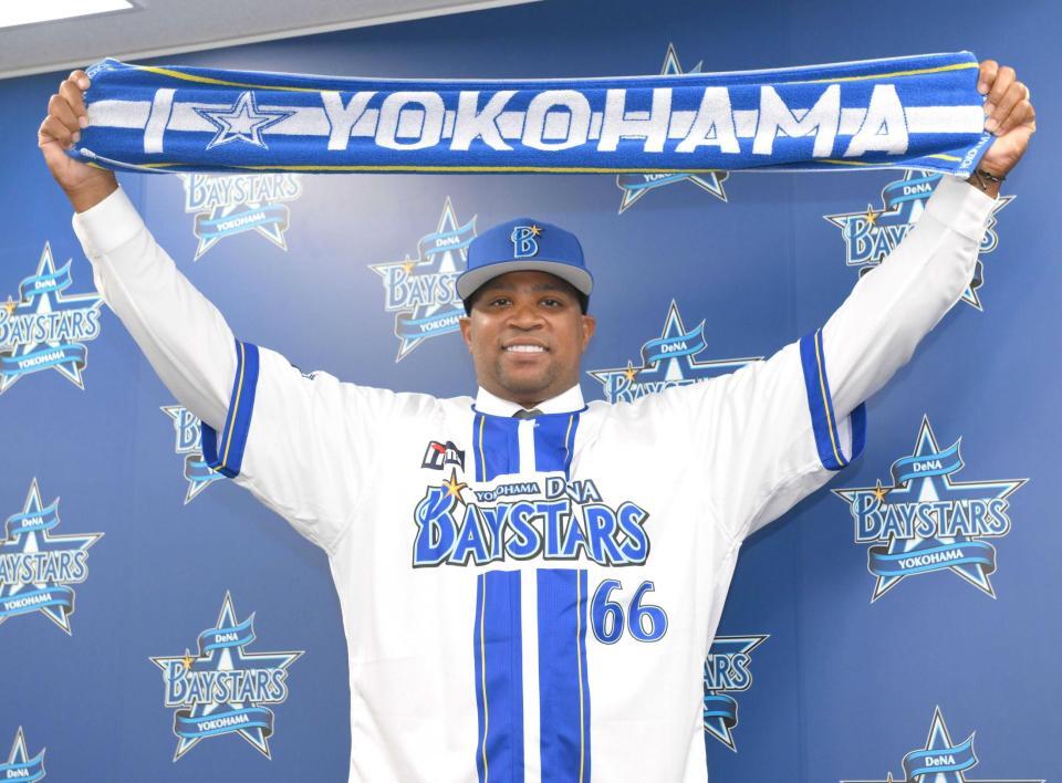 　入団会見でマフラータオルを掲げるビシエド（撮影・伊藤笙子）