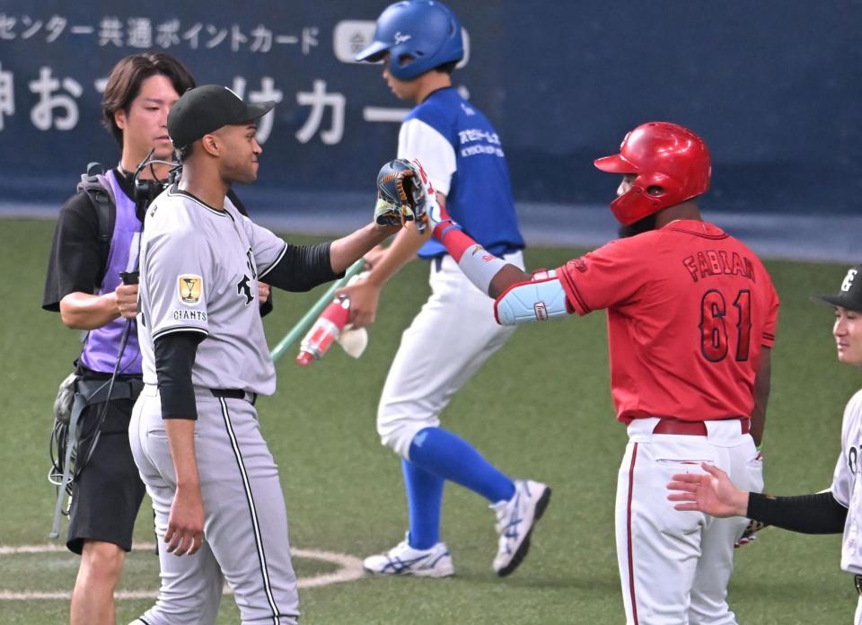 　１回を抑え、ファビアンとタッチを交わすマルティネス（撮影・飯室逸平）