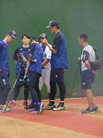 　ブルペンでの投球練習後、データを確認する藤浪（中）＝横須賀市