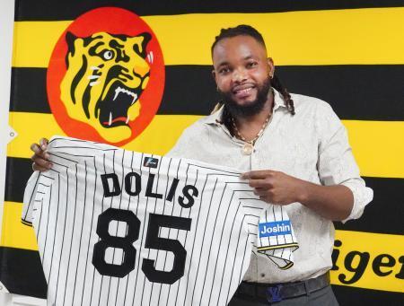 　阪神に復帰し、記者会見後にユニホームを手にするドリス＝２４日、兵庫県西宮市