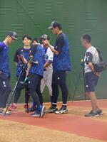 　ブルペンでの投球練習後、データを確認する藤浪（中）＝横須賀市