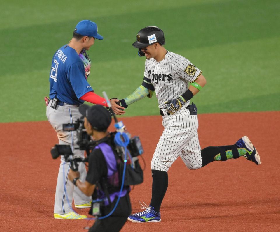 　５回、右越えソロを放ち、清宮幸（左）とタッチする佐藤輝（撮影・伊藤笙子）