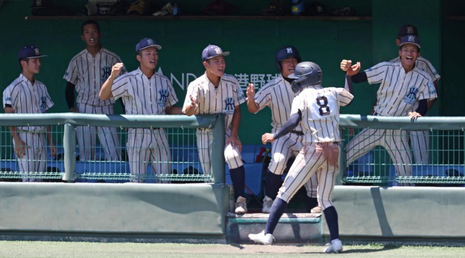 　１０回、暴投で勝ち越しの生還を果たした上田留生（８）を迎える東大阪大柏原ナイン（撮影・中田匡峻）