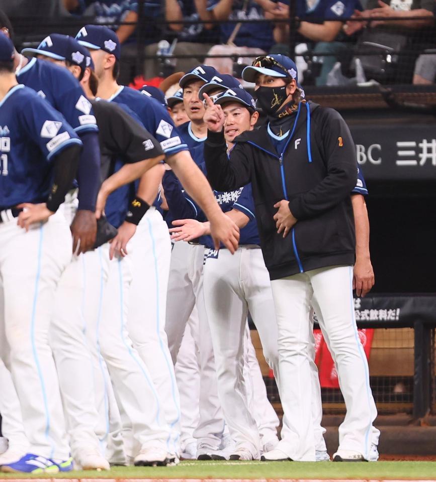 　柴田らナインを迎える新庄監督（右）＝撮影・中島達哉