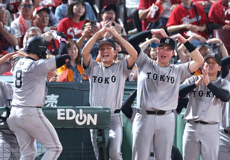 　９回、右越えソロを放った丸（８）を「丸ポーズ」で迎える坂本（左）とリチャード（撮影・市尻達拡）