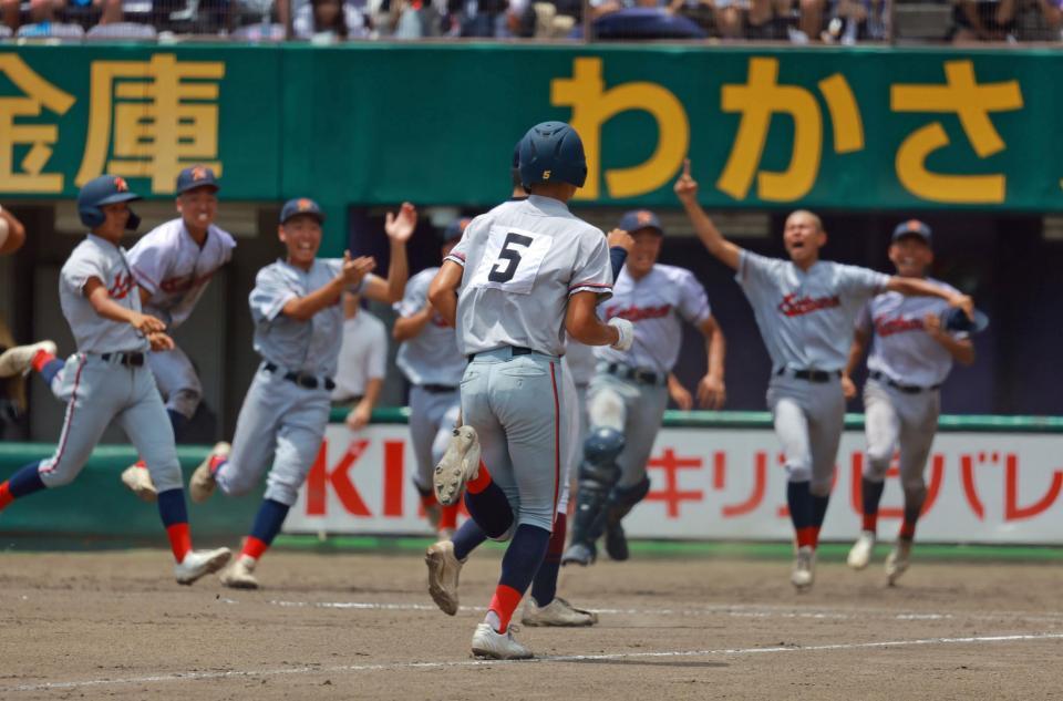 　サヨナラのホームに向かう清水（中央）を迎え入れる京都国際ナイン（撮影・石湯恒介）