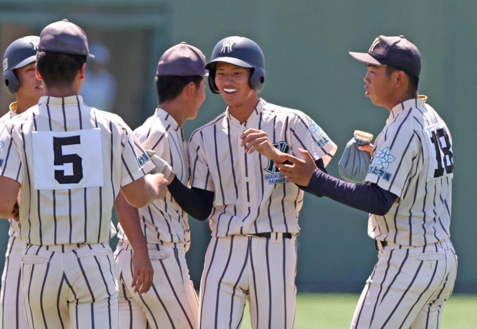 　２回、右中間へ先制となる２点適時二塁打を放ち、ナインとタッチを交わす東大阪大柏原・川崎龍輝（中央）＝撮影・中田匡峻
