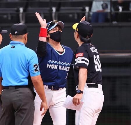 　メンバー表を交換し、帰り際に小久保監督（右）とハイタッチを交わす新庄監督（中央）＝撮影・中島達哉