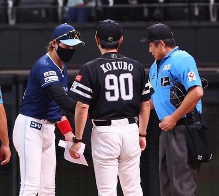 　メンバー表を交換し、小久保監督（９０）とは握手せず、審判と握手を交わす新庄監督（左）＝撮影・中島達哉