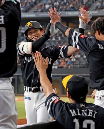 　１回、先頭打者本塁打を放ちナインに迎えられる周東（左）