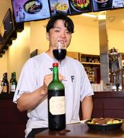 　ワインを片手にポーズをとる郡司（撮影・中島達哉）