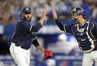 　５回を無失点に抑え、古賀（右）とタッチを交わすアビラ（撮影・西岡正）