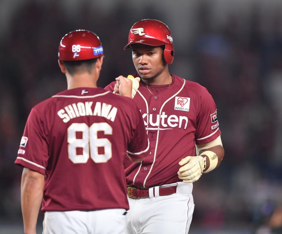 　５回、左前適時打を放ち塩川コーチ（手前）とグータッチを交わすゴンザレス（撮影・開出牧）