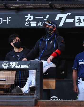 　２回、赤いリストバンドを片腕に２つ着けて、笑顔を見せる新庄監督（右）＝３０日