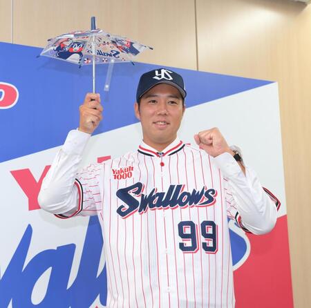 　入団会見で応援の傘を手に笑顔を見せる青柳（撮影・伊藤笙子）