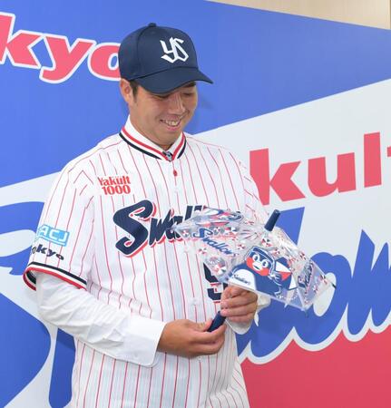 　フォトセッションで応援用の傘を渡され、苦笑いの青柳（撮影・伊藤笙子）