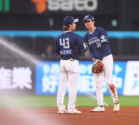 　６回、スプリンクラーが誤作動し、水野（左）と話す石井（撮影・中島達哉）