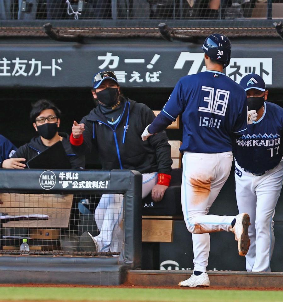 　２回、水野のスクイズで生還した石井（３８）を迎える新庄監督（３０日）