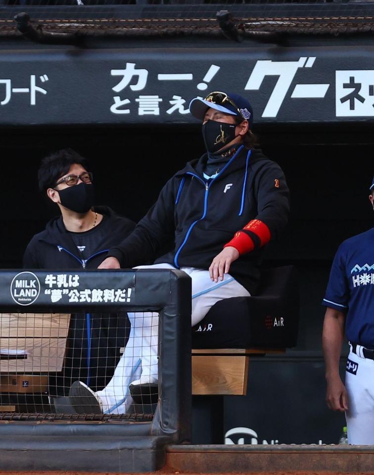 　２回、赤いリストバンドを片腕に２つ着けて、笑顔を見せる新庄監督（右）＝３０日