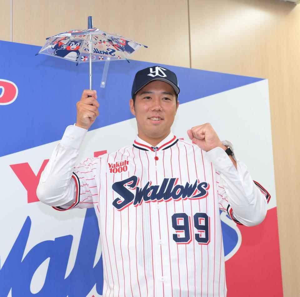 　入団会見で応援の傘を手に笑顔を見せる青柳（撮影・伊藤笙子）