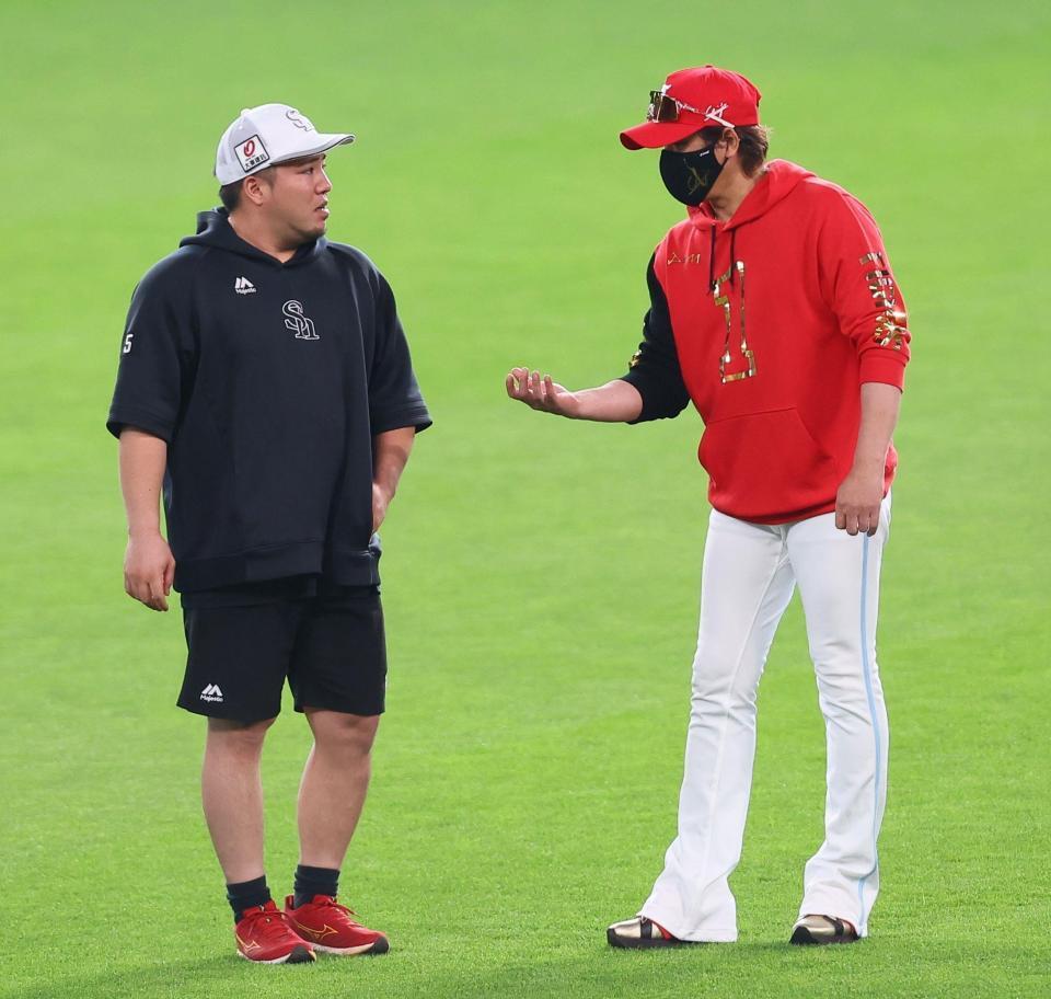　試合前、山川（左）と話をする新庄監督（撮影・中島達哉）