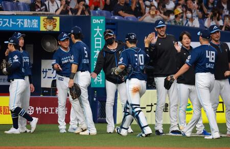 　ナインと勝利のタッチを交わす新庄監督（撮影・石湯恒介）