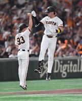 　６回、左越え２ランを放ち松本コーチ（左）とジャンピングタッチを交わすキャベッジ（撮影・開出牧）