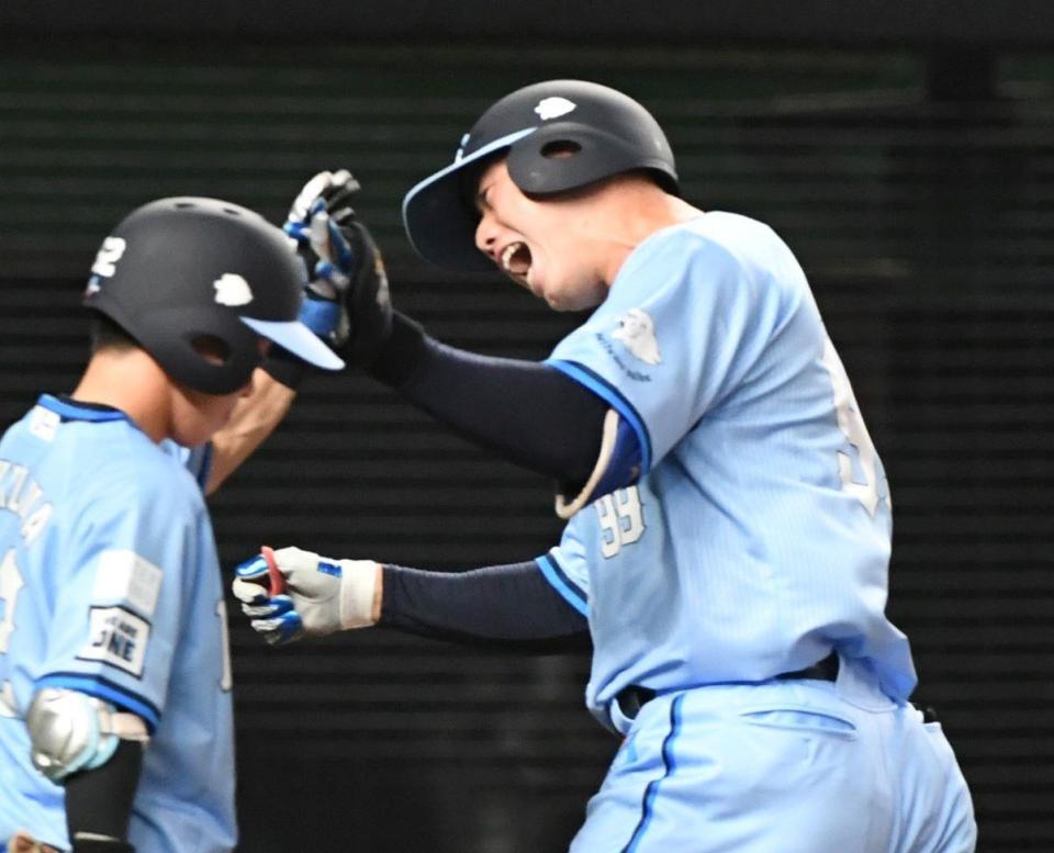 　１０回、村田は左越えにプロ初本塁打を放ち、滝沢（左）に迎えられる（撮影・佐藤厚）