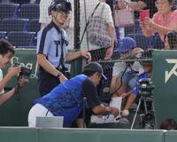 　練習中、一生懸命声をかけていた少年に応えて、カメラ席に入ってサインする三浦監督（撮影・吉澤敬太）