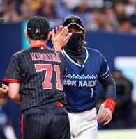 　岸田監督とのメンバー表の交換を終え、ハイタッチする新庄監督（撮影・山口登）