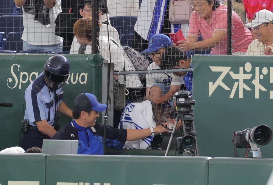 　練習中、一生懸命声をかけていた少年に応えて、カメラ席に入ってサインする三浦監督（撮影・吉澤敬太）