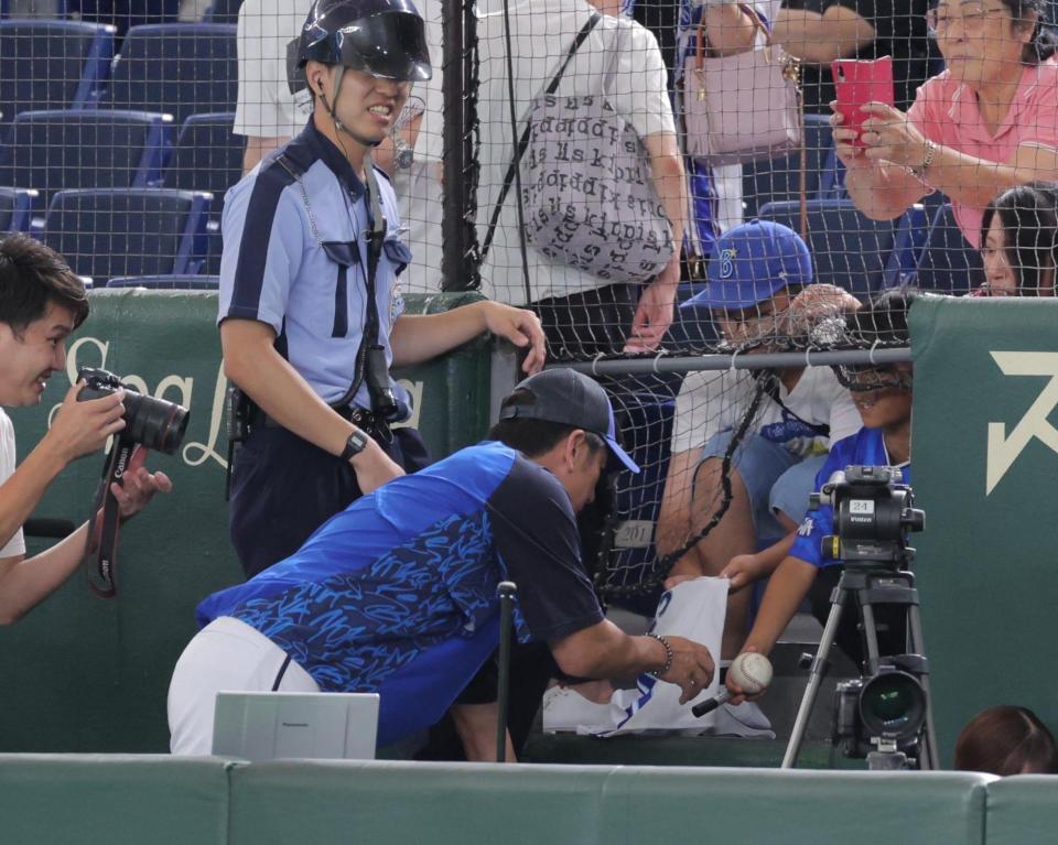 　練習中、一生懸命声をかけていた少年に応えて、カメラ席に入ってサインする三浦監督（撮影・吉澤敬太）