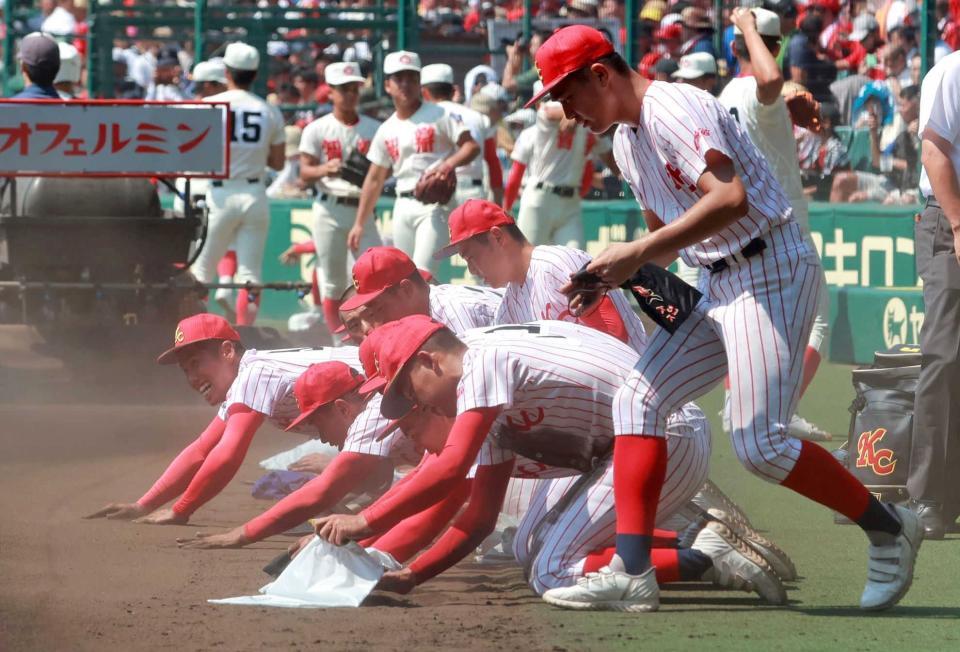 　砂を拾い集める高知中央ナイン＝２０２３年８月