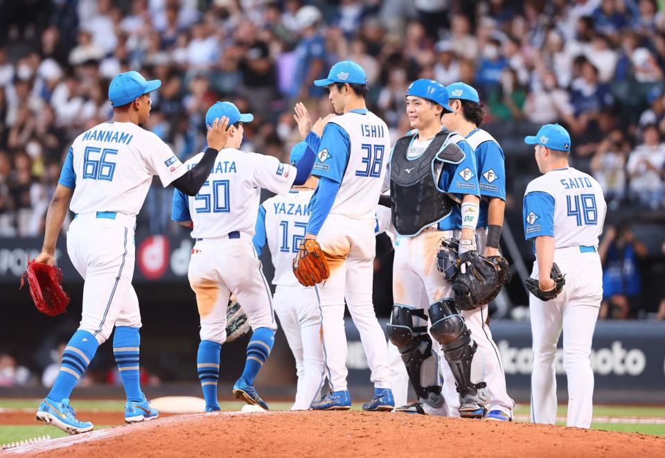 　西武に勝利をあげ、タッチを交わす日本ハムナイン（撮影・中島達哉）