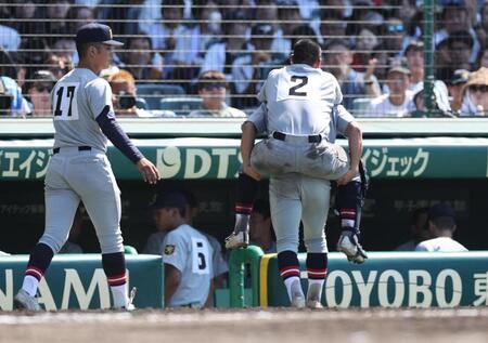 　７回裏終了後、足を痛め、背負われてベンチに引き揚げる仙台育英の捕手川尻