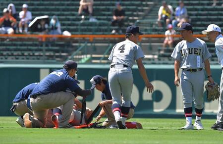 　８回表終了後もベンチへ戻れず、担架で運ばれる仙台育英・田山纏。右は須江監督（撮影・出月俊成）