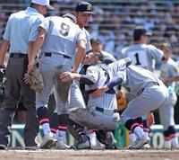 　７回裏の守備を終えたところで、足を痛めてしゃがみ込仙台育英のむ捕手川尻（手前右から２人目）