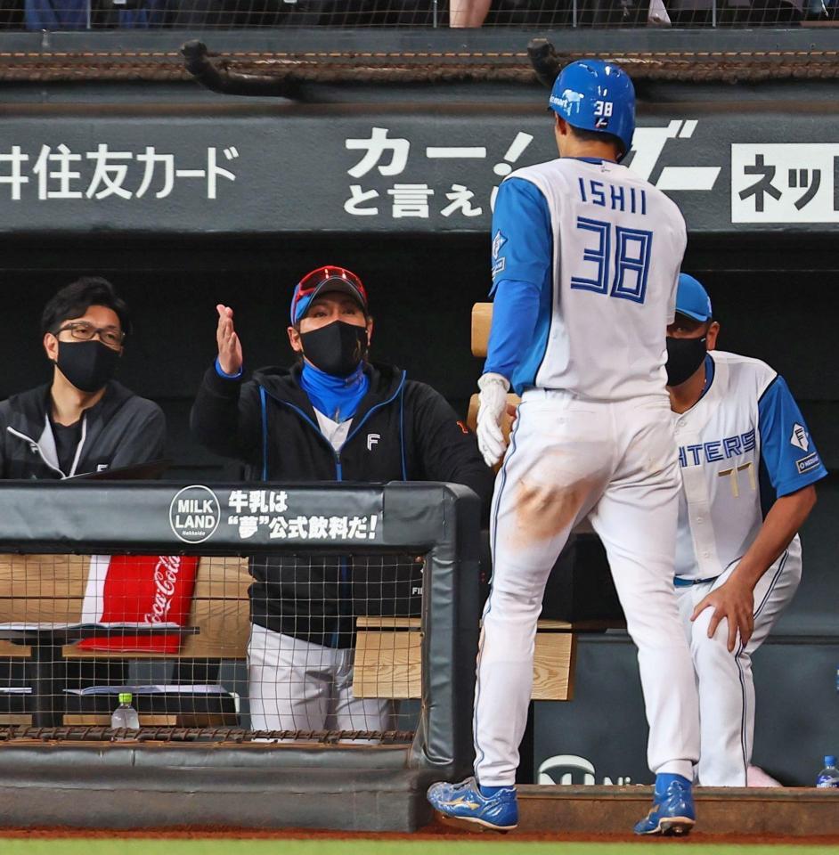 　２回、松本剛の先制打で生還した石井（３８）を迎える新庄監督（中央）＝撮影・中島達哉