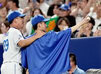 　プロ初勝利を挙げた金丸は井上監督に激励されながら、家族が見守るスタンドへボールを掲げる（撮影・田中太一）