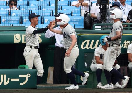 　４回、沢田蓮の同点２点適時打で生還した走者を迎える弘前学院聖愛・原田一範監督（左）＝撮影・中田匡峻