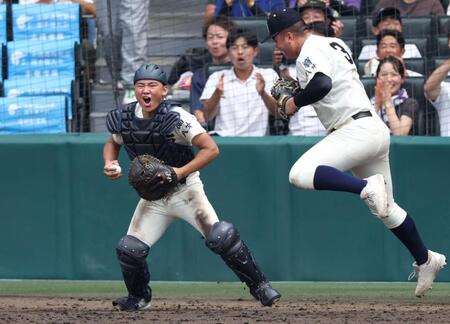　１０回、弘前学院聖愛・菅野裕真の邪飛を好捕した西日本短大付・山下航輝（左）＝撮影・中田匡峻