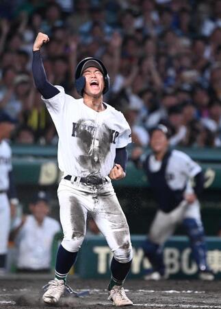 　１０回、山下のサヨナラスクイズで生還しガッツポーズする佐賀北の三走・塚原