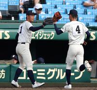 　３回を投げ終え、ベンチ前で田中柊真（右）とタッチを交わす弘前学院聖愛・芹川丈治（撮影・中田匡峻）